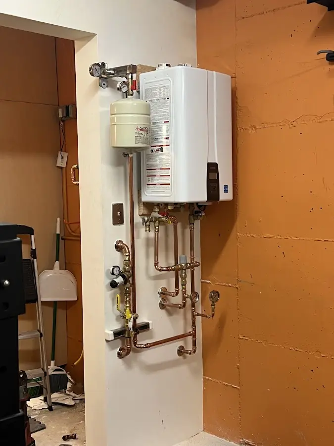 Plumbing technician inspecting water heater connections in Everman